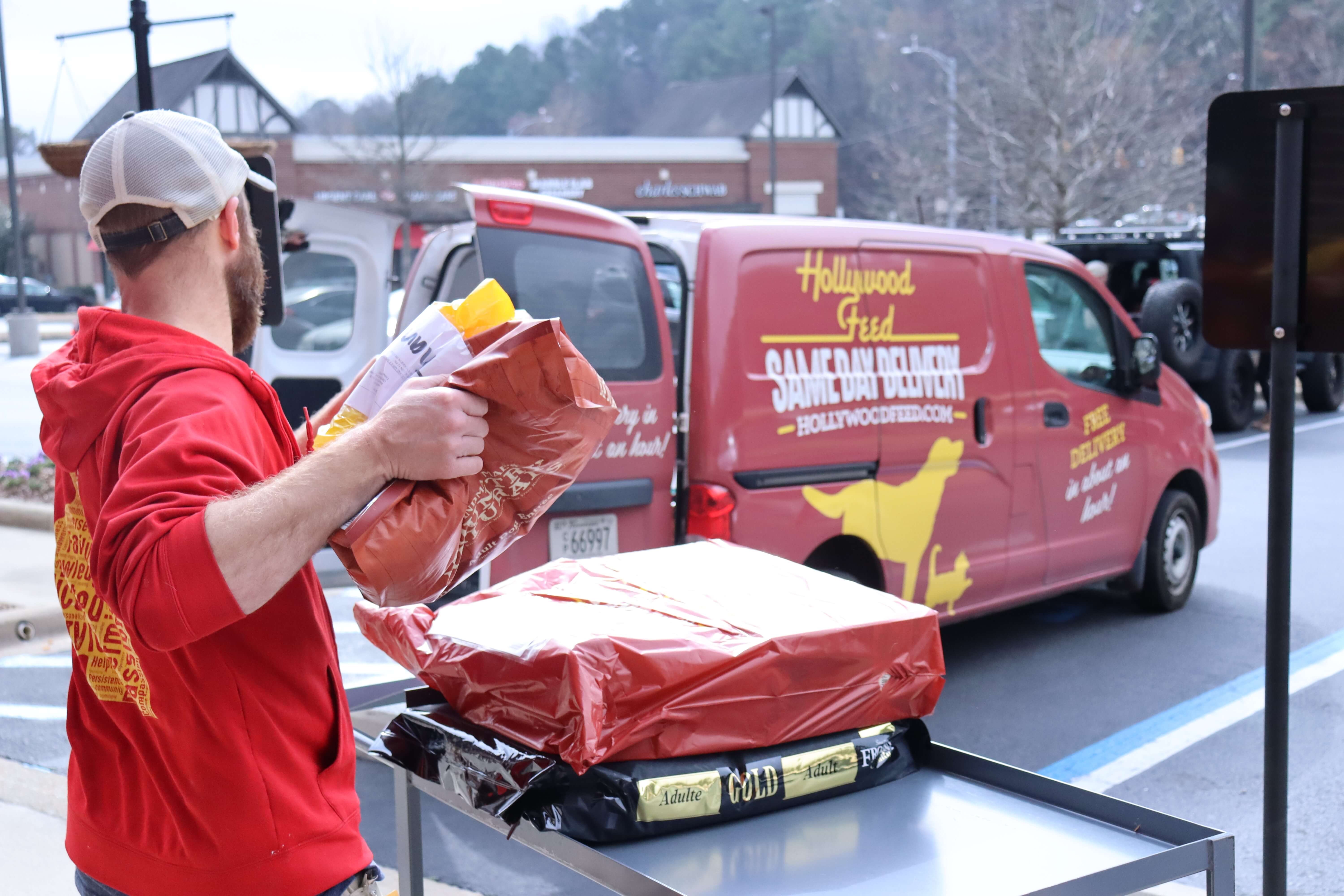 Person loading Same Day Delivery packages on the Same Day Delivery vehicle